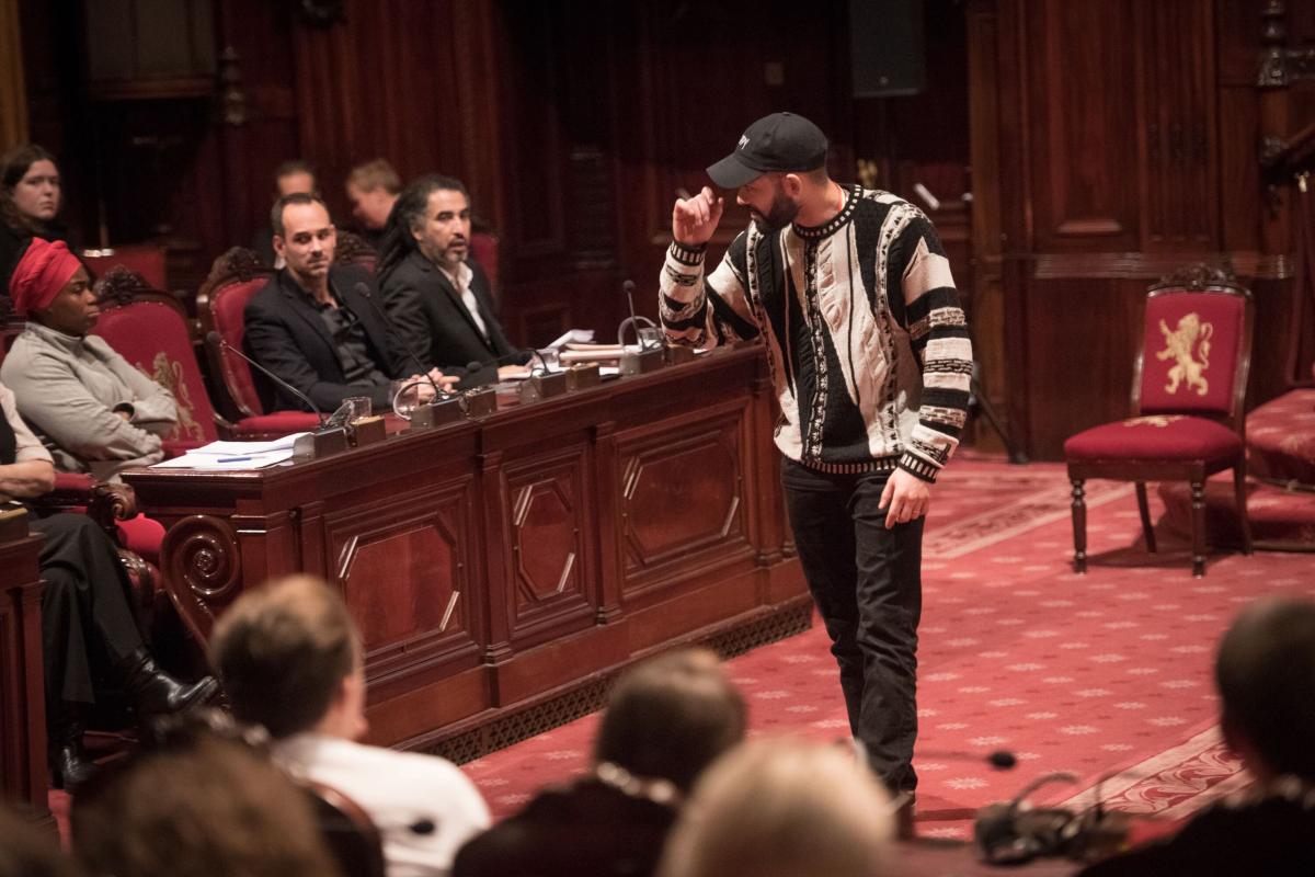 Acteur maakt zich kwaad, links zitten drie getuigen te luisteren naar zijn getuigenis. 